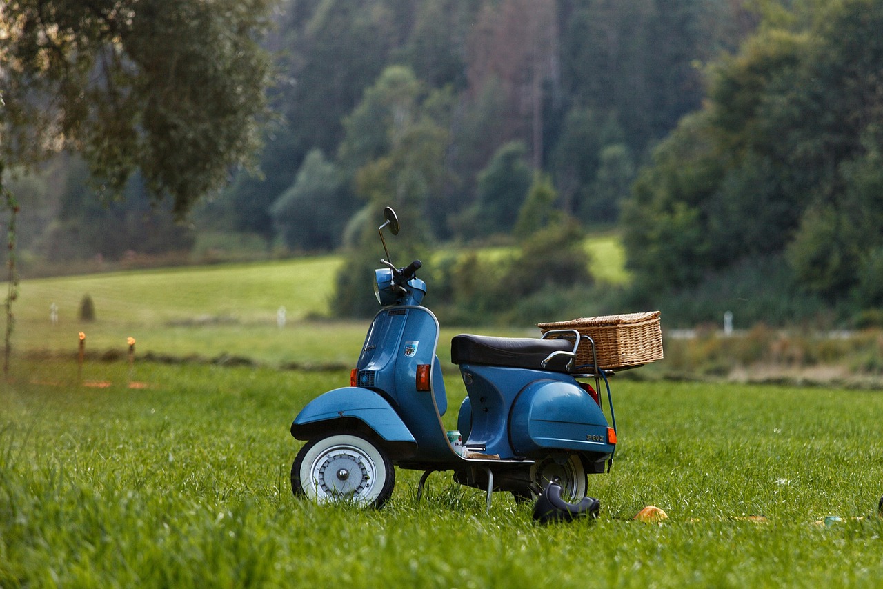 Scooter geparkeerd in het gras, als illustratie bij het verzekeren van brommers en scooters.